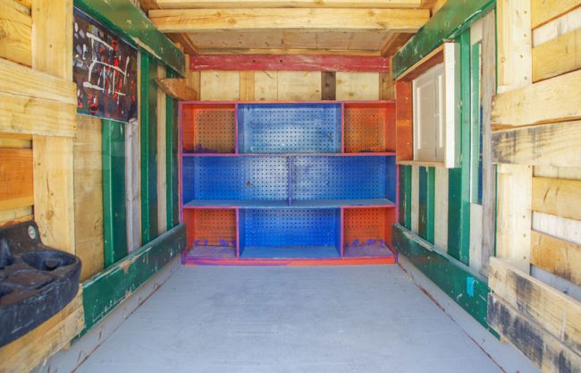 the interior of the structure is fitted with a shelving unit and a painting