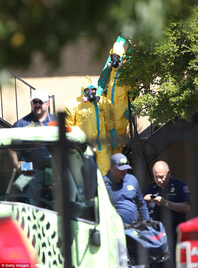 A hazmat team leave the apartment in Dallas as the crew decontaminated the home - removing a mattress that Ebola patient Thomas Duncan had slept on, along with sheets and a suitcase he brought from Liberia 